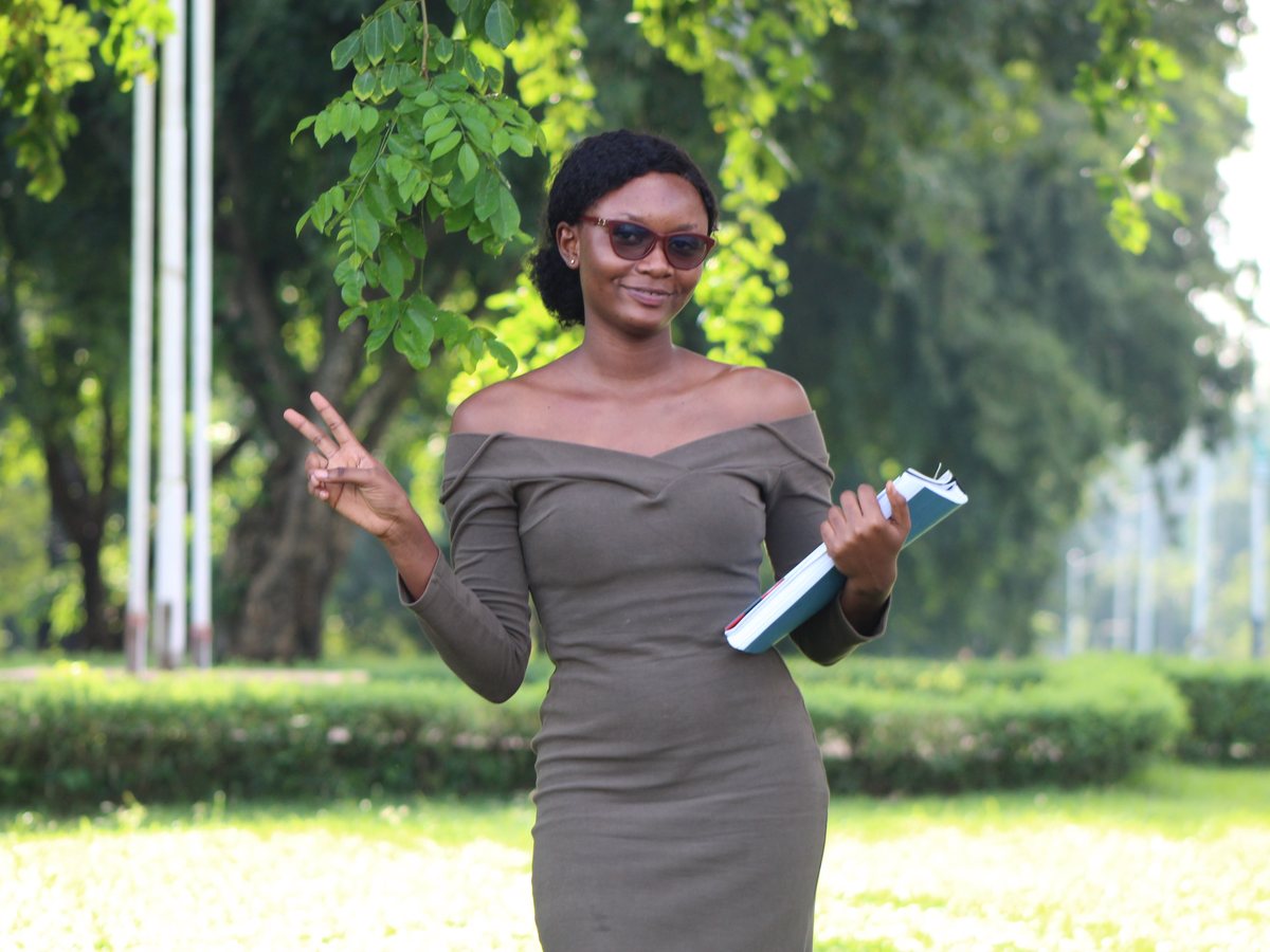 An African university student holding study materials on campus