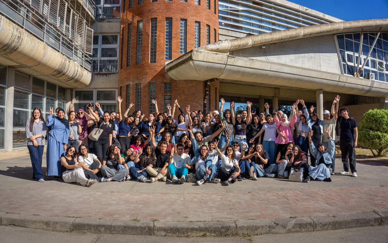 A diverse group of international students celebrating on a university campus
